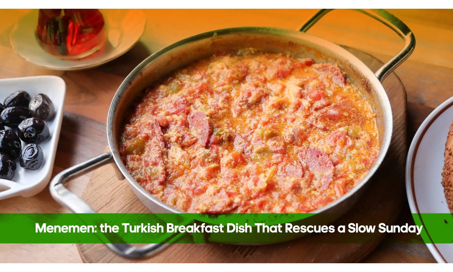 Menemen, Turkish scrambled eggs with tomatoes and peppers, served in a pan with olives and tea
