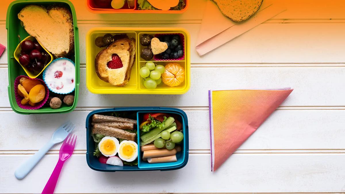 Three healthy halal packed lunch boxes with fruit, boiled eggs, sandwiches and vegetables