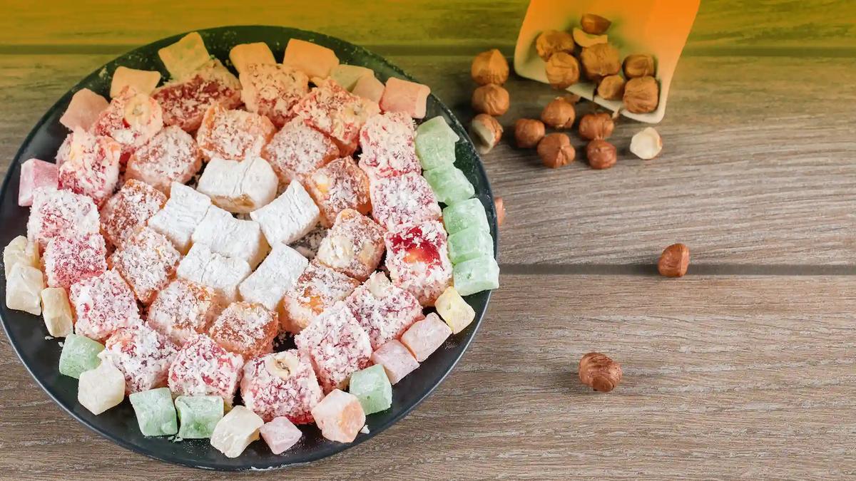 Serving Turkish delight Plate of mixed Turkish delight cubes dusted with icing sugar, served with hazelnuts